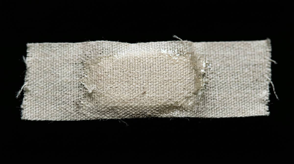 A close-up of a used bandage on a black background