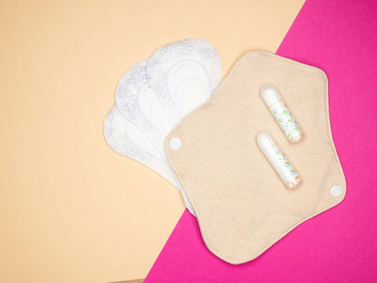 Infographic showing composition of conventional vs. certified organic menstrual pads: conventional pads contain 90% plastic including polyethylene backing, synthetic absorbent gel, and fragrances; organic pads use GOTS-certified cotton, plant-based cellulose, and compostable wrappers.