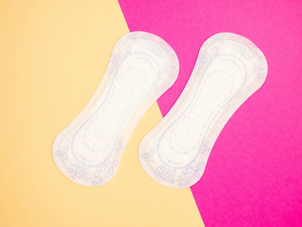 Menstrual health products and supplies (pads, tampons, menstrual cups or reusable cups) on a colorful background.