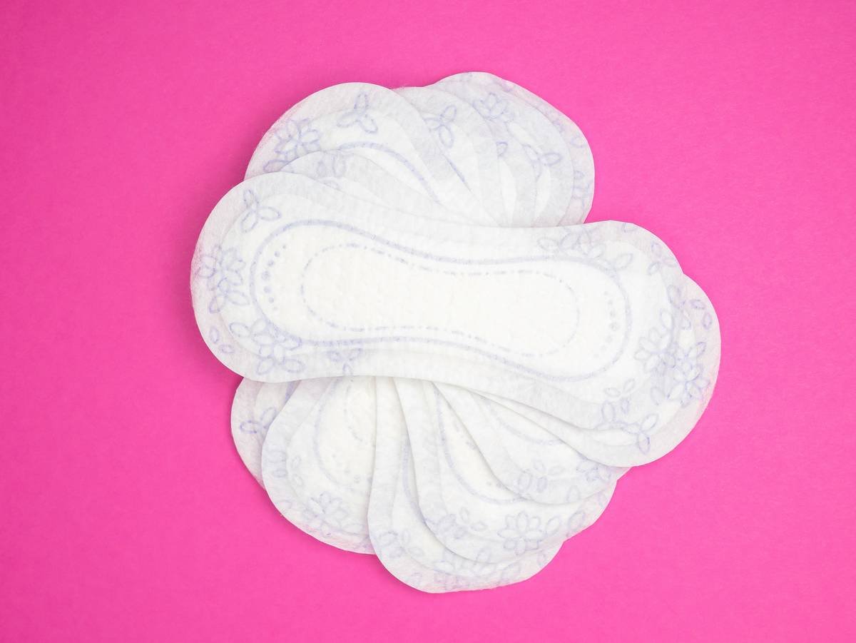 Menstrual products and supplies (pads, tampons, menstrual cups) on a colorful background.