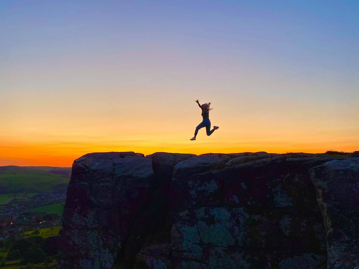 a person jumping off a cliff into the air
