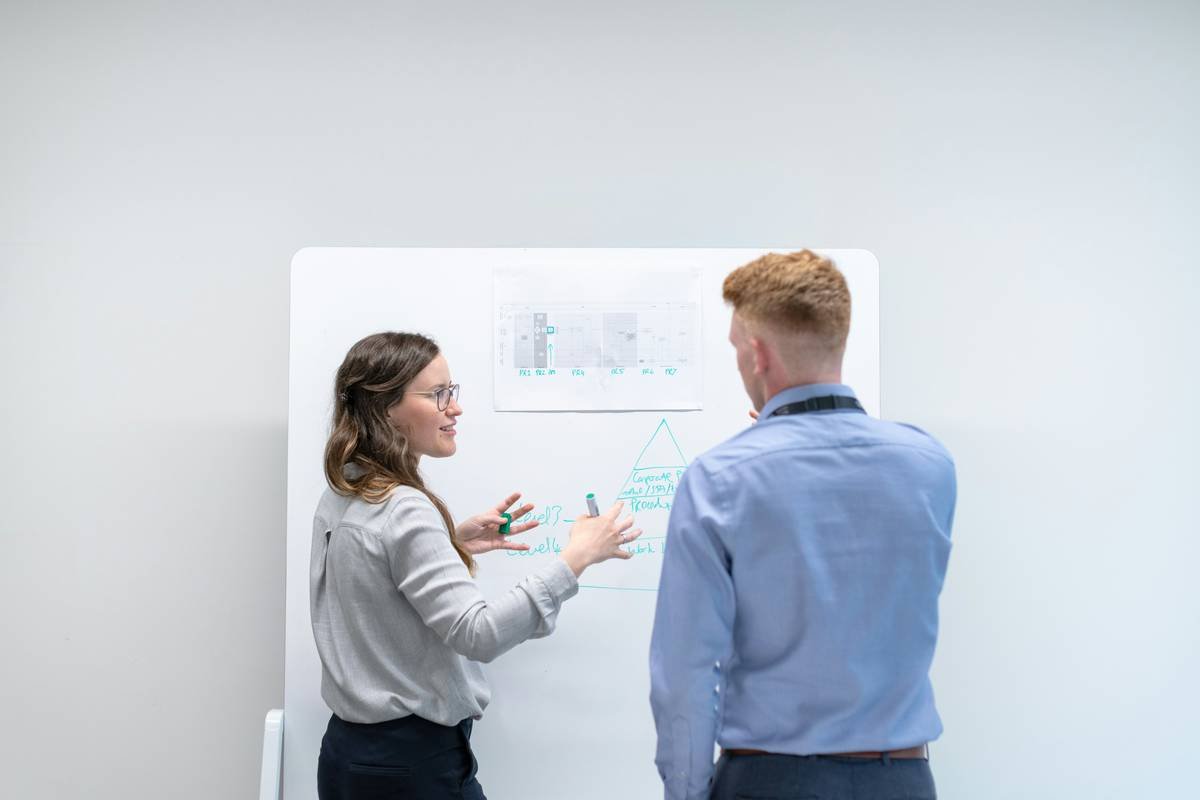 Female electronics engineer discusses data in meeting with colleague