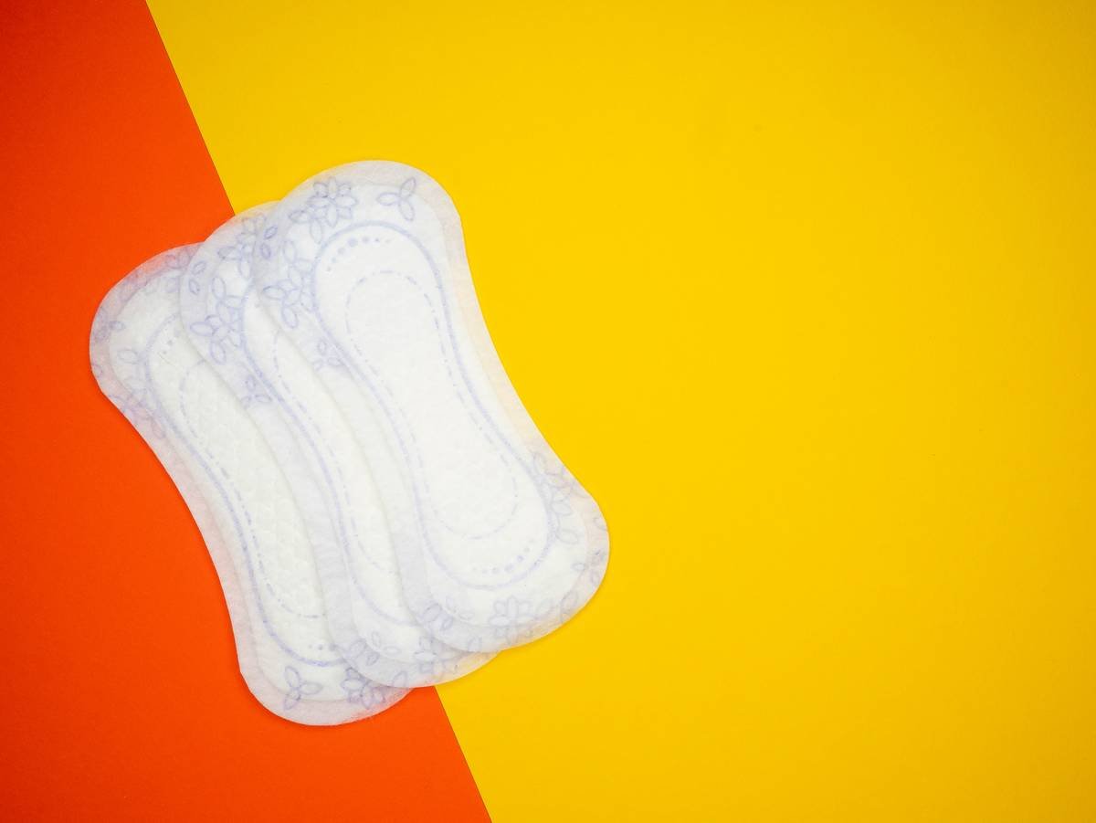Infographic comparing ingredients in conventional pads (plastic, fragrance, rayon) vs. hygiene organic pads (certified organic cotton, plant-based backsheet, no chlorine)