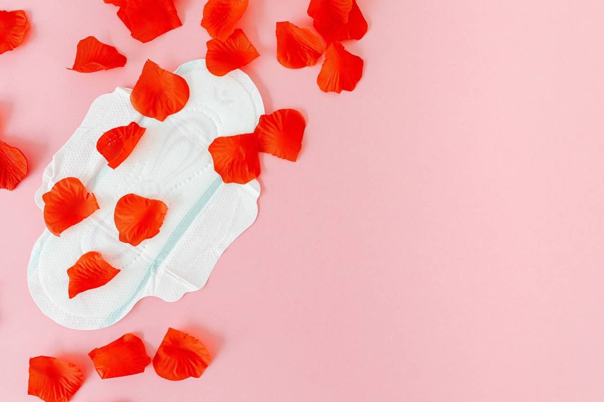 Infographic comparing organic cotton pad (left) with layers: GOTS-certified cotton top sheet, compostable core, plant-based adhesive) vs conventional pad (right): plastic backing, chlorine-bleached rayon, synthetic gel, fragrance chemicals