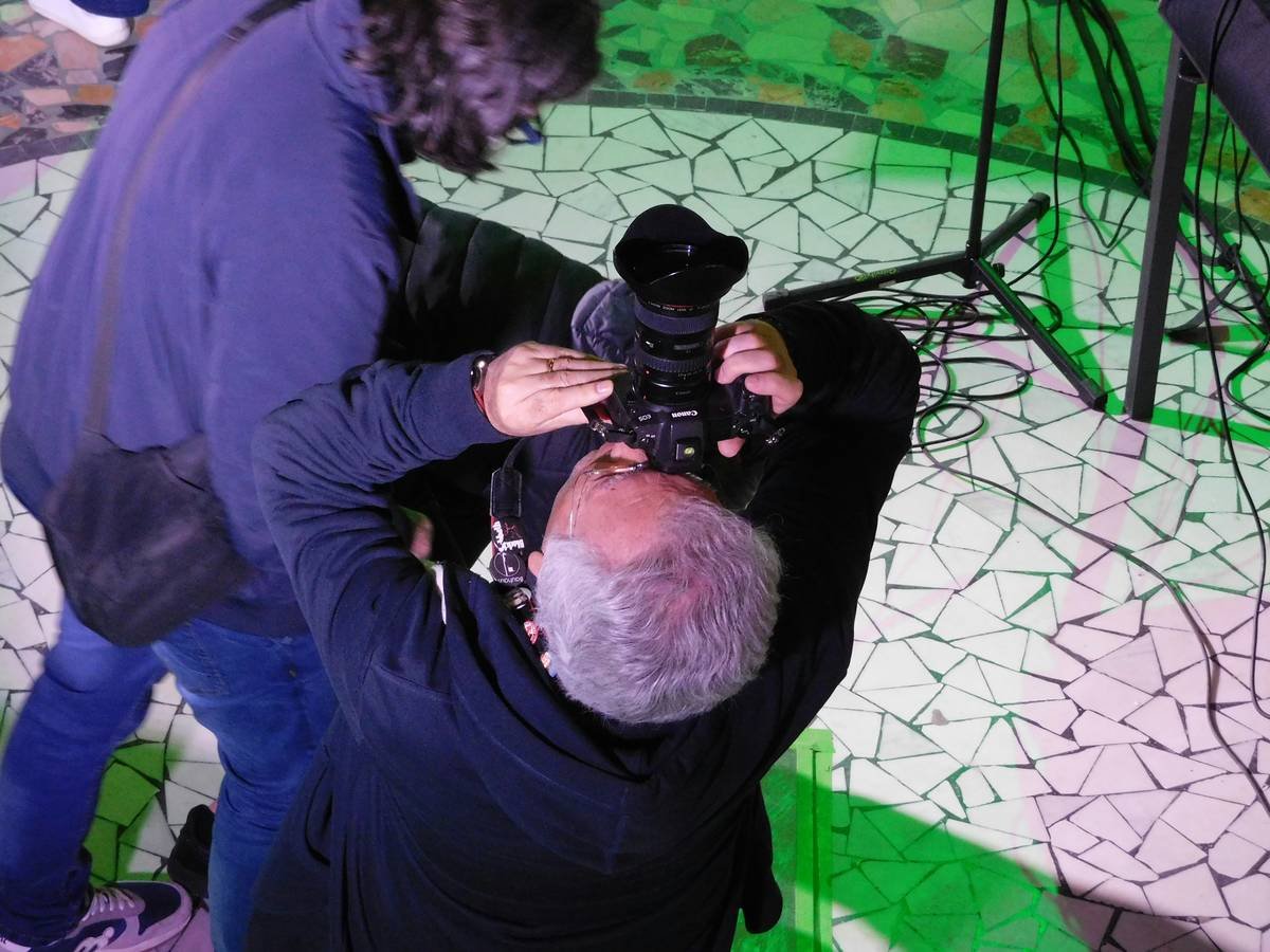 Two people with a camera filming an event.